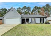 Gray house with white garage door and green lawn at 470 Paris Dr, Lawrenceville, GA 30043