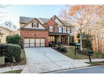 Brick two-story house with a large driveway and landscaping at 2725 Monet Dr, Cumming, GA 30041