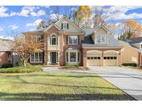 Brick two-story home with a three-car garage and manicured lawn at 280 Tumbling Creek Dr, Alpharetta, GA 30005