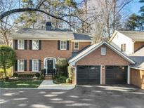 Brick home with two-car garage and landscaped lawn at 20 Pointe Se Ter, Atlanta, GA 30339