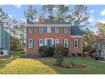 Brick two-story house with a landscaped lawn and attached garage at 4663 Brazil Wood Nw Dr, Kennesaw, GA 30144