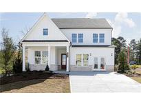 Two story farmhouse style home with white siding, brick accents and a welcoming front porch at 224 Artisan Dr, Acworth, GA 30102