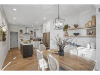 Open-concept kitchen and dining area with white cabinets, wood floors, and island at 4490 Mariners Rdg, Alpharetta, GA 30005