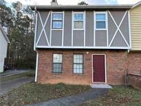 Brick townhouse exterior with a burgundy door and landscaping at 3506 Ten Oaks Ct, Powder Springs, GA 30127