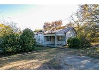 Ranch style home with a covered porch and mature trees at 492 S Cherokee Rd, Social Circle, GA 30025