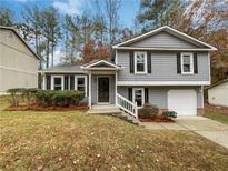 Gray two-story house with a landscaped lawn and attached garage at 320 Kimberly Forest Ct, Atlanta, GA 30349