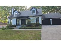 Charming two-story house with a two-car garage and landscaped lawn at 1947 Kensington High Sw St, Lilburn, GA 30047