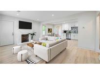 Bright living room featuring hardwood floors, a sectional sofa, and a modern fireplace at 1676 Sylvan Sw Rd, Atlanta, GA 30316