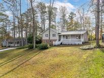 Ranch house with large backyard, covered porch, and mature trees at 322 Pioneer Cir, Woodstock, GA 30188