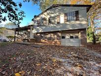 Brick ranch home with attached garage and mature trees. Needs some TLC at 8423 Avalon Dr, Riverdale, GA 30274