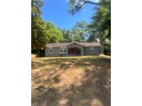 Gray house with red door, front yard, and mature trees at 226 Howell Sw Dr, Atlanta, GA 30331