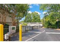 Gated community entrance with intercom system and lush landscaping at 6940 Roswell Rd # C14, Atlanta, GA 30328