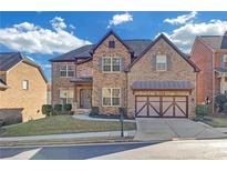 Two-story brick home with a three-car garage and landscaped yard at 3628 Union Park Dr, Duluth, GA 30097