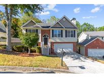 Two-story house with brick and siding exterior, attached garage, and landscaped yard at 2140 Wildcat Cliffs Way, Lawrenceville, GA 30043