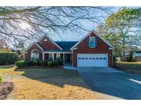 Brick home with attached garage and landscaped lawn at 1987 Ridge Water Ln, Lawrenceville, GA 30045