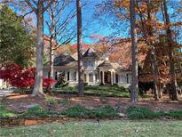 Two-story house with a gray exterior, landscaping, and a stone wall at 6730 Polo Dr, Cumming, GA 30040