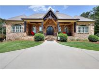 Stone and shingle exterior of a charming two-story home with a large covered porch at 4079 Bullock Bridge Rd, Loganville, GA 30052