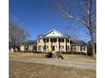 Brick home with a grand entrance, columns, and a manicured lawn at 3637 Linda Dr, Loganville, GA 30052