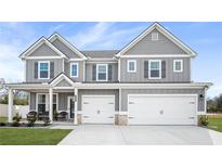 Two story gray house with white accents, three car garage, and front porch at 1049 Bodega Loop, Locust Grove, GA 30248