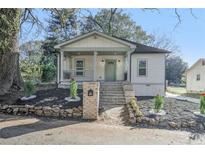 Newly constructed home with front porch and landscaped yard at 5445 Eva Mamie Ln, Stone Mountain, GA 30083