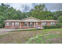 Ranch-style brick home with a ramp and carport at 2413 Kennesaw Due West Nw Rd, Kennesaw, GA 30152