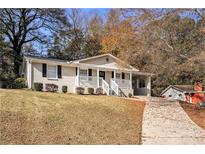 Charming two-story home with a driveway, front porch, and landscaping at 896 Meadow Rock Way, Stone Mountain, GA 30083