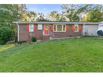 Brick ranch house with red shutters, a large yard, and a long driveway at 5932 Gresham Sw Pl, Mableton, GA 30126