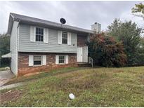 Two-story house with brick and siding, satellite dish, and mature landscaping at 125 Belmont Farms Dr, Ellenwood, GA 30294