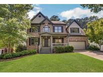 Brick two-story house with a large front yard and mature trees at 1054 Sunny Field Ln, Lawrenceville, GA 30043