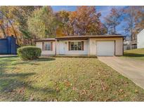 Ranch style home with attached garage and mature trees at 5267 Tasman Trl, Lithonia, GA 30038