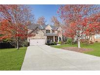 Two-story house with brick facade and a long driveway, surrounded by autumn trees at 3670 Falling Leaf Ln, Cumming, GA 30041