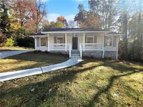Charming ranch home with white brick exterior, covered porch, and landscaped yard at 2320 Capehart Ne Cir, Atlanta, GA 30345