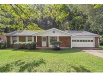Brick ranch house with attached garage and a spacious lawn at 2616 Landington Nw Way, Duluth, GA 30096