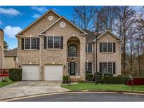 Brick two-story house with a two car garage and landscaped lawn at 3224 Wooded Glen Se Ct, Smyrna, GA 30082