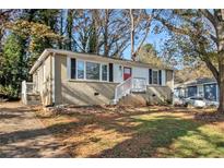 Brick ranch home with a landscaped yard and a red front door at 1425 Cobb Branch Dr, Decatur, GA 30032