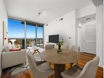 Bright living room with hardwood floors, city views, and a dining area at 361 17Th Nw St # 1618, Atlanta, GA 30363