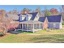 Two-story home with wraparound porch and landscaped yard at 3975 Mcconnell Rd, Cumming, GA 30028