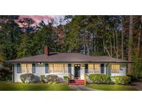 Charming ranch house with white brick exterior, landscaped lawn, and mature trees at 1403 Centra Villa Dr, Atlanta, GA 30311