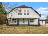 White farmhouse with black accents, covered porch, and large windows at 6219 Heardsville Rd, Cumming, GA 30028