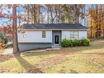 Ranch style home with gray siding and landscaping at 2326 Chestnut Log Dr, Lithia Springs, GA 30122