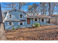 Light blue house with a covered porch and a tree-filled yard at 2080 Bluffton Way, Decatur, GA 30035