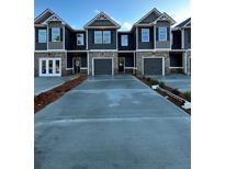 Three-unit townhome building with gray siding, two-car garages, and a shared driveway at 253 Ivey Ter # 48, Temple, GA 30179