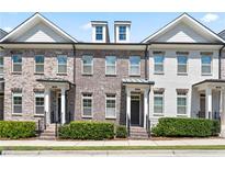 Three-unit townhome building with brick and white siding at 3879 Glenview Club Ln, Duluth, GA 30097