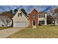 Two-story brick and vinyl home with attached garage and landscaped lawn at 3374 River Mill Ln, Ellenwood, GA 30294