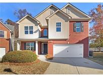 Two-story house with brick and beige siding, a two-car garage, and landscaping at 4578 Chafin Point Ct, Snellville, GA 30039