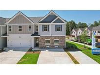 Two-story townhome with gray and beige siding, brick accents, and a two-car garage at 318 Crimson Dr, Union City, GA 30291