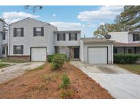 Two-story townhome with attached garage and landscaping at 703 Pine Tree Trl, Atlanta, GA 30349