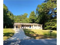 Charming ranch home with a long driveway and beautiful landscaping at 3263 Dodson Dr, Atlanta, GA 30344