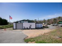 Commercial building with large roll-up door and ample parking at 1793 Johnson Road, Cumming, GA 30040