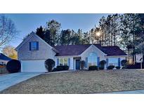 Brick house with a landscaped yard and driveway at 1361 Log Cabin Se Ln, Lawrenceville, GA 30045